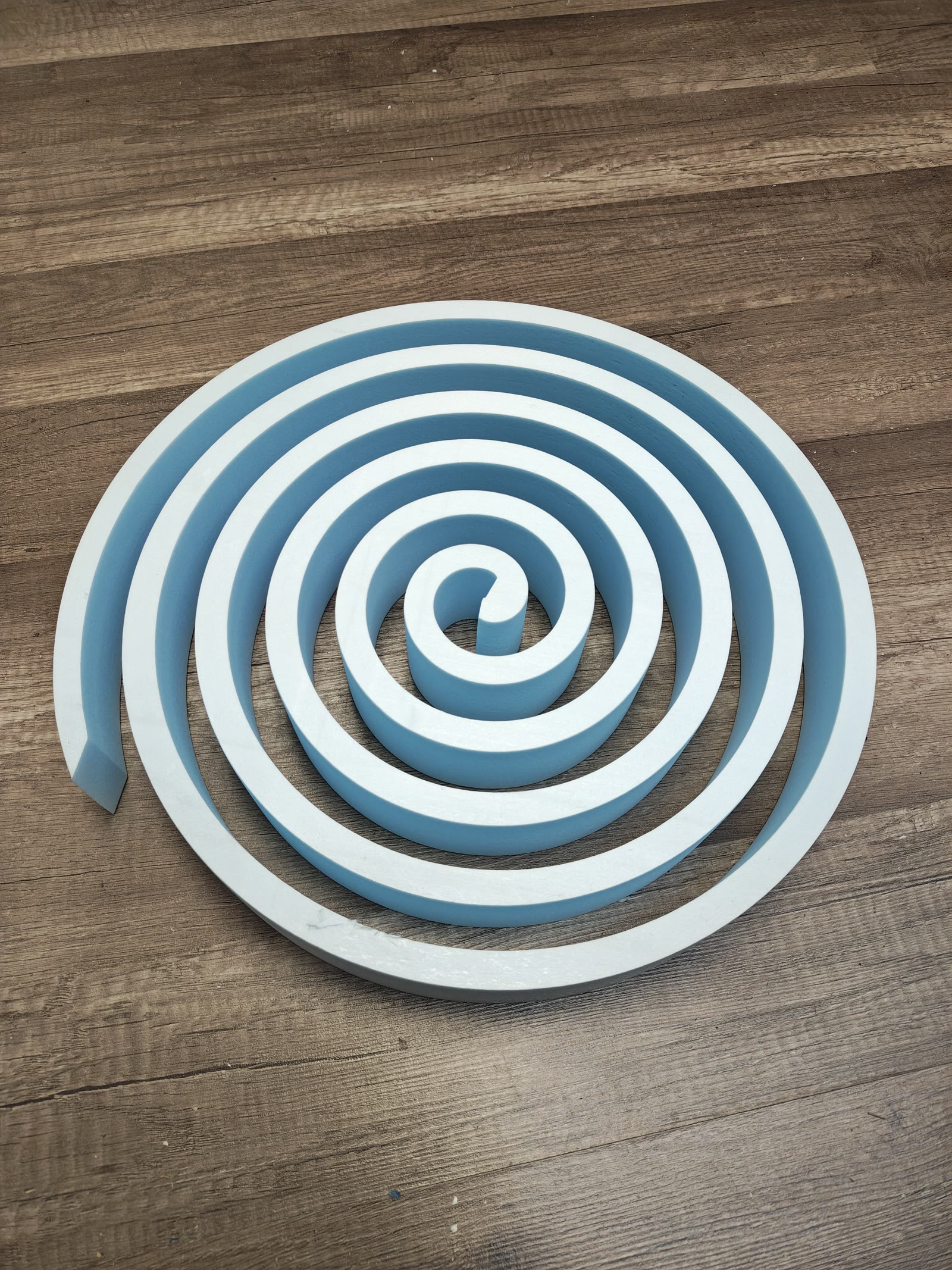 Finished spiral foam part on a wood floor